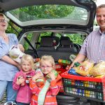 Sandra Radünz, ihr Mann Marcus, Tochter Zoe (2. v. re) und Freundin Ilvy vor dem bis unters Dach mit Spenden beladenen Auto