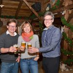 André Rosinski (rechts), Hansjörg Conzelmann und Birte Friedländer stoßen auf die Alpenhütte an. Foto: Katrin Gehrke