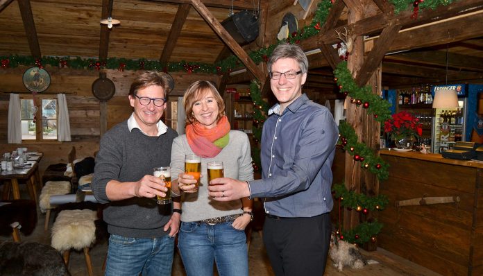 André Rosinski (rechts), Hansjörg Conzelmann und Birte Friedländer stoßen auf die Alpenhütte an. Foto: Katrin Gehrke