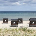 Edle Strandkörbe gehören zur perfekten Aus-stattung des Hauses: Sitzkomfort mit Stil und dem HAMPTONS-Logo am Scharbeutzer Strand