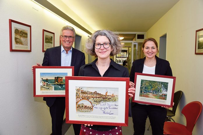 Mit Bildern aus vergangener Zeit: Bürgermeister Volker Owerien (li), Bürgermeisterin Hatice Kara und Archivleiterin Melanie Zühlke (vorn)