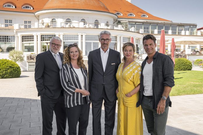 Das Schauspieler-Team gemeinsam mit Hoteldirektor Kay Plesse (Mitte) vor dem stilvollen Gebäude des ATLANTIC Grand Hotel Travemünde