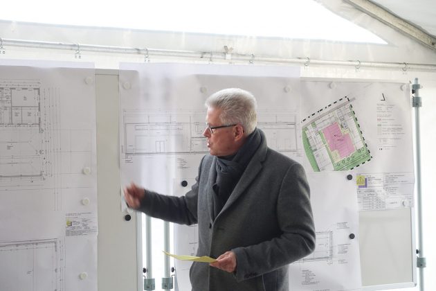 Bürgermeister Volker Owerien erklärt den zahlreichen Zuschauern den Bauplan für das Gemeindehaus in Schürsdorf