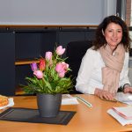 Bürgermeisterin Bettina Schäfer an ihrem Schreibtisch im Bürgerhaus von Scharbeutz. Käsekuchen und Blumen haben ihr die Kollegen zur Begrüßung auf den Schreibtisch gestellt. © Katrin Gehrke