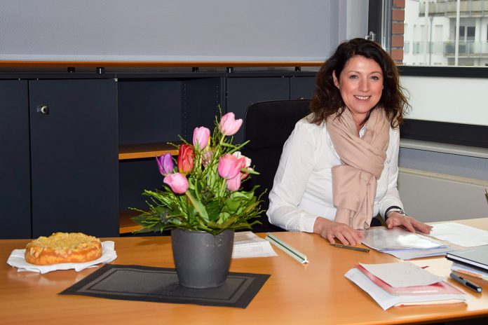 Bürgermeisterin Bettina Schäfer an ihrem Schreibtisch im Bürgerhaus von Scharbeutz. Käsekuchen und Blumen haben ihr die Kollegen zur Begrüßung auf den Schreibtisch gestellt. © Katrin Gehrke
