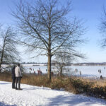 Eisvergnügen auf dem Pönitzer See: Schlittschuhläufer, Eissegler und Wanderer genießen Sonne und Winterzauber.